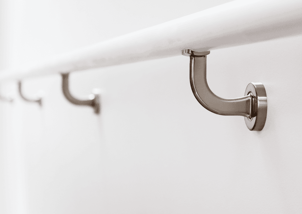 Satin nickel bannister brackets supporting a white handrail